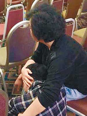 北京發布會現場有家屬坐在地上痛哭。（中新社圖片）