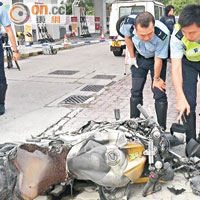 警員檢視嚴重燒毀的肇事電單車。（許錦雄攝）