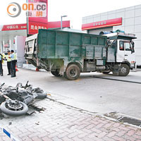 肇事貨車駛入油站等候拖走檢驗，損毀電單車翻側路旁。