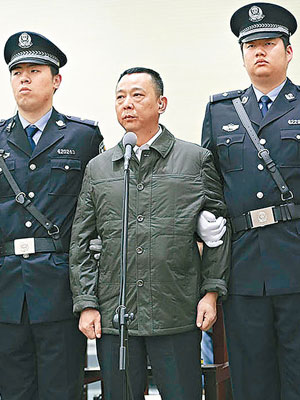 劉漢（中）由兩名庭警押上法庭受審。（互聯網圖片）