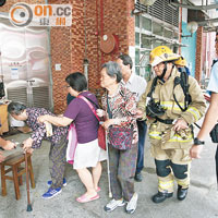 警方及消防員協助行動不便長者疏散。（左錦鴻攝）