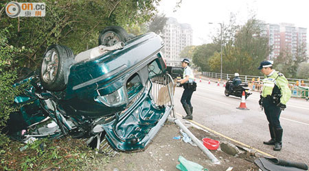 私家車翻入草叢四輪朝天。（沈厚錚攝）