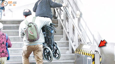 有乘坐輪椅的長者因沒有鎖匙，未能使用升降台（箭嘴示），須自行步上梯級，輪椅則他人協助搬動。