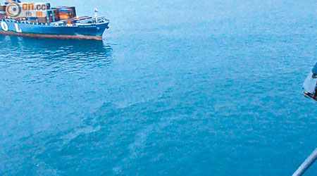 涉事的貨櫃船停在現場，海面有油污及雜物。（飛行服務隊提供）