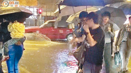 旺角<br>暴雨水浸下巿民在街道上異常狼狽。（高潤榮攝）