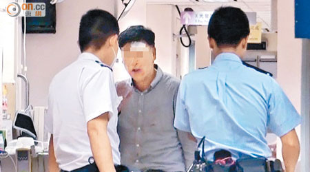 額頭受傷的涉事韓籍男子向警員解釋事件。 （王偉安攝）