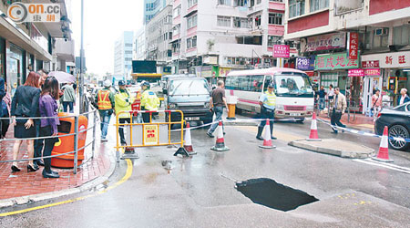 警員圍封路陷現場，防止人車接近。（吳遠輝攝）