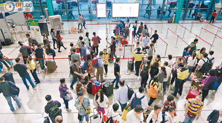 香港<br>昨日傍晚大批旅客在紅磡直通車入口外等候及查詢車務最新情況。（朱先儒攝）