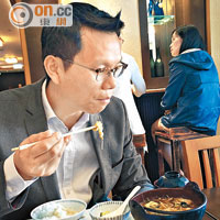 陳恒鑌在「拉布」期間食飯要透過手機睇實立法會個「大市」，準備隨時起跑返回會議廳。（周依露攝）