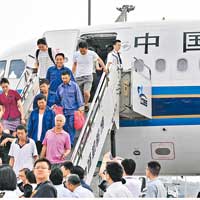 乘包機返國的中資企業員工走下包機。（中新社圖片）