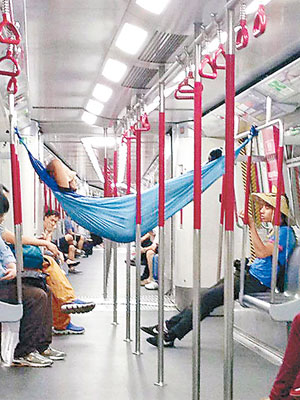 一名男乘客在兩邊扶手柱掛起一張吊床，然後在吊床睡覺。（互聯網圖片）