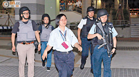 屋邨女保安引領身穿避彈衣及持長槍的警員封鎖現場。（麥少峰攝）