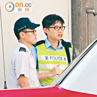 救護車車長（左）向警員講述經過。