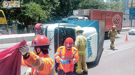 肇事貨車翻側橫亘路中，消防員正救援被困傷者。（網民Kwong Chi Leung攝）