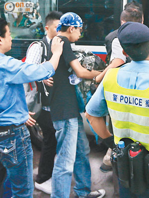 姓袁少年被押上警車，當時他手抱一個背囊。