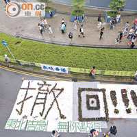 反東北示威者用盆栽砌成「撤回」大字。（梁鵬威攝）