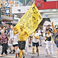 有藝術工作者昨化身「黃色人」，由銅鑼灣街頭跑至中聯辦。（何天成攝）