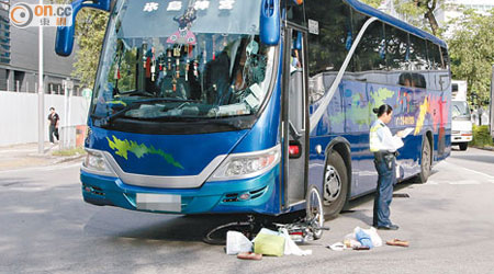 單車捲入車底，物品散滿地。（黃永健攝）