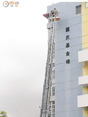 工人乘消防雲梯在學校外牆滅蜂。（曾紹良攝）