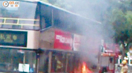 巴士車底冒煙起火，消防員開喉灌救。（讀者提供）