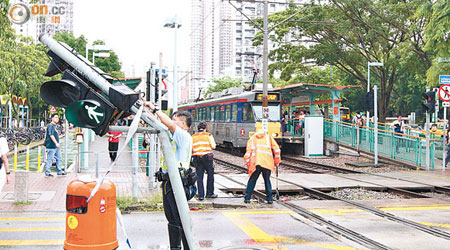 客貨車與輕鐵相撞後，再撼倒交通燈柱。（楊日權攝）