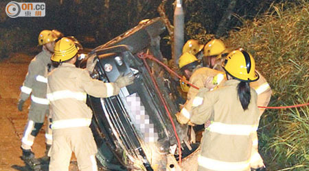 消防員合力將翻側車輛「扶正」。（胡德威攝）