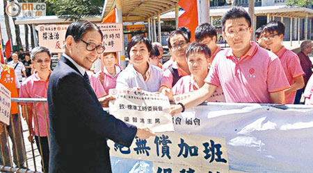 工會代表向梁智鴻（左）遞交請願信，要求政府盡快就標準工時立法。