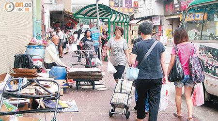 行人路被公然佔用堆放手推車及紙皮等雜物，影響環境衞生。