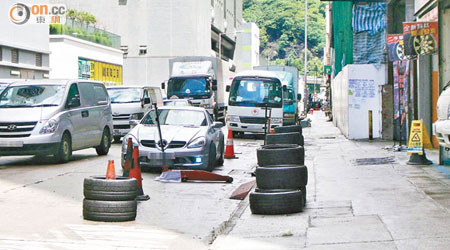 行車路面長期擺放維修汽車工具及車胎等雜物，惹市民不滿。