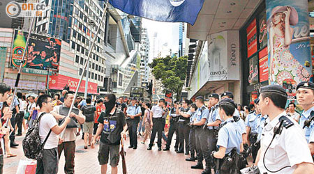 示威者高舉港英旗狙擊反佔中簽名街站，警方派出廿多人維持秩序。（高嘉業攝）