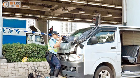 肇事客貨車車頭損毀，警員在現場檢視調查。（黃君堡攝）