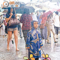紅色暴雨警告期間，本港多處下着傾盆大雨，市民撐起雨傘擋雨。（陳章存攝）
