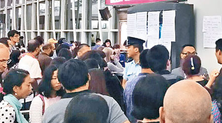 滯留在機場禁區的國航乘客鼓譟，驚動警員到場處理。（互聯網圖片）