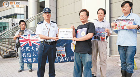 「香港人優先」數名成員到灣仔警察總部請願，指參與反佔中大遊行市民涉嫌違反國旗法。（溫國佳攝）