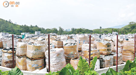 大量電子垃圾被層層疊堆放於露天回收場內，貨物高度足逾兩個成年人。