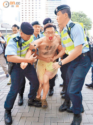 多名警員合力將自稱為行為藝術家的示威裸男帶走。（陳章存攝）