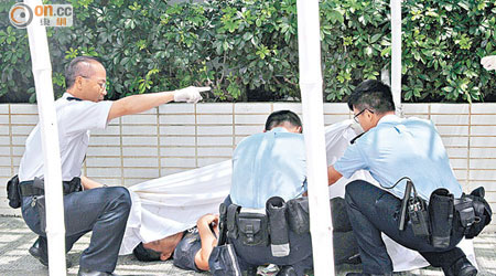 警員檢查死者的屍體。（曾志恒攝）