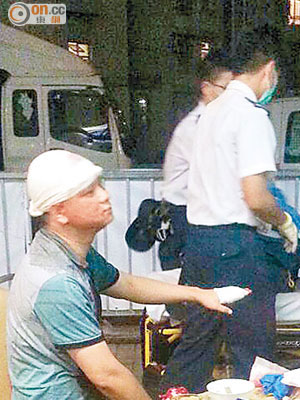 遭爆樽扑穿頭部的傷者，由救護員包紮。（讀者提供）