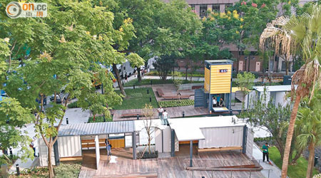 駿業街公園四個貨櫃箱的藝術裝置由樹木環抱。