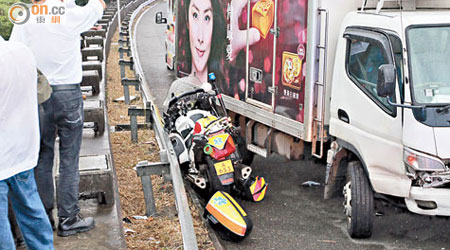 救護電單車被夾在貨車和鐵欄之間。（黃永健攝）