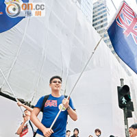 約十名激進示威者手持港英龍獅旗「踩場」抗議。（梁鵬威攝）