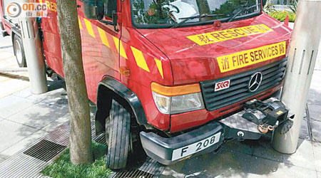 首宗車禍<br>肇事消防搶救車車頭損毀，夾於樹及燈柱之間。（讀者提供）