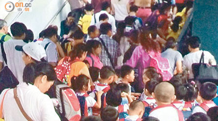 大批水貨客與跨境學童擠在落馬洲支線管制站通往離境大堂的唯一樓梯。（讀者提供）