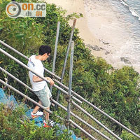用臨時梯<br>市民走過土木工程拓展署搭建的臨時樓梯，再攀爬棚架才能抵沙灘。