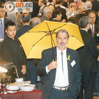 大部分泛民議員杯葛酒會，唯一出席的區議員司馬文則撐起黃傘示威。（何天成攝）