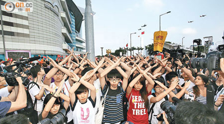 學民思潮等示威者在升旗時，背對五星旗、雙手打叉示威。（黃仲民攝）