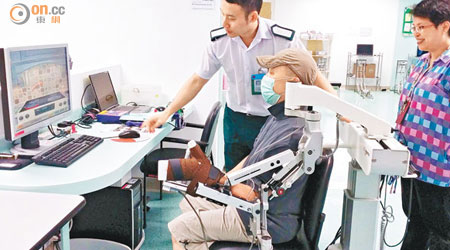 機械臂會配合電腦遊戲，幫助中風病人恢復手部活動能力。（張美蘭攝）