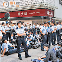 有警員與示威者通宵對峙後倦極坐地休息。