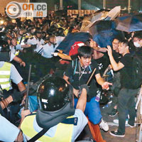 昨午夜後撐傘的示威者與揮棍的警員衝突，有人血流披面。
