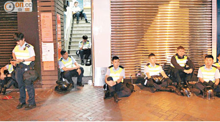 筋疲力盡的警員坐在地面稍作休息。